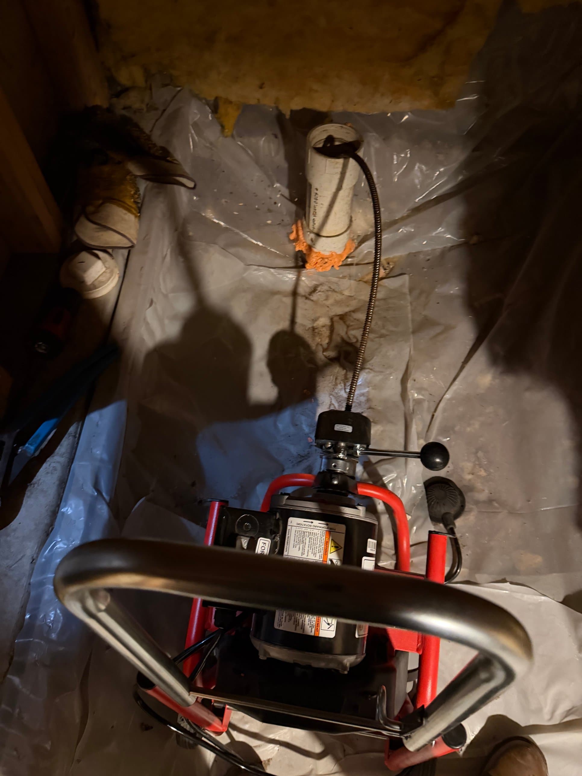 Professional drain cleaning service in Aurora, CO — Zenith Home Services technician using a Ridgid sectional cable machine to snake a drain line in a crawl space