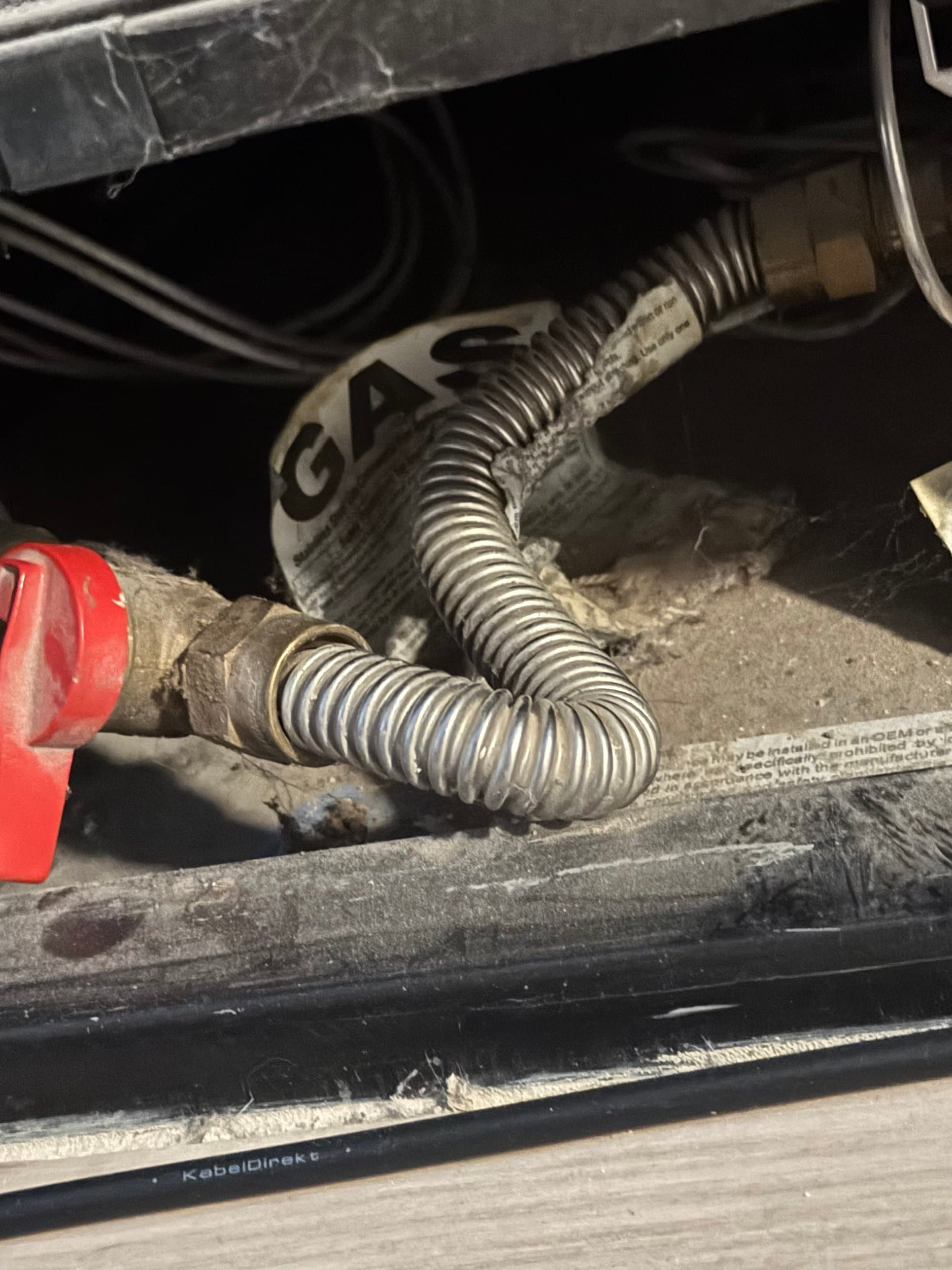 Old corroded flexible gas connector being replaced during gas line service in Aurora, CO — Zenith Home Services technician