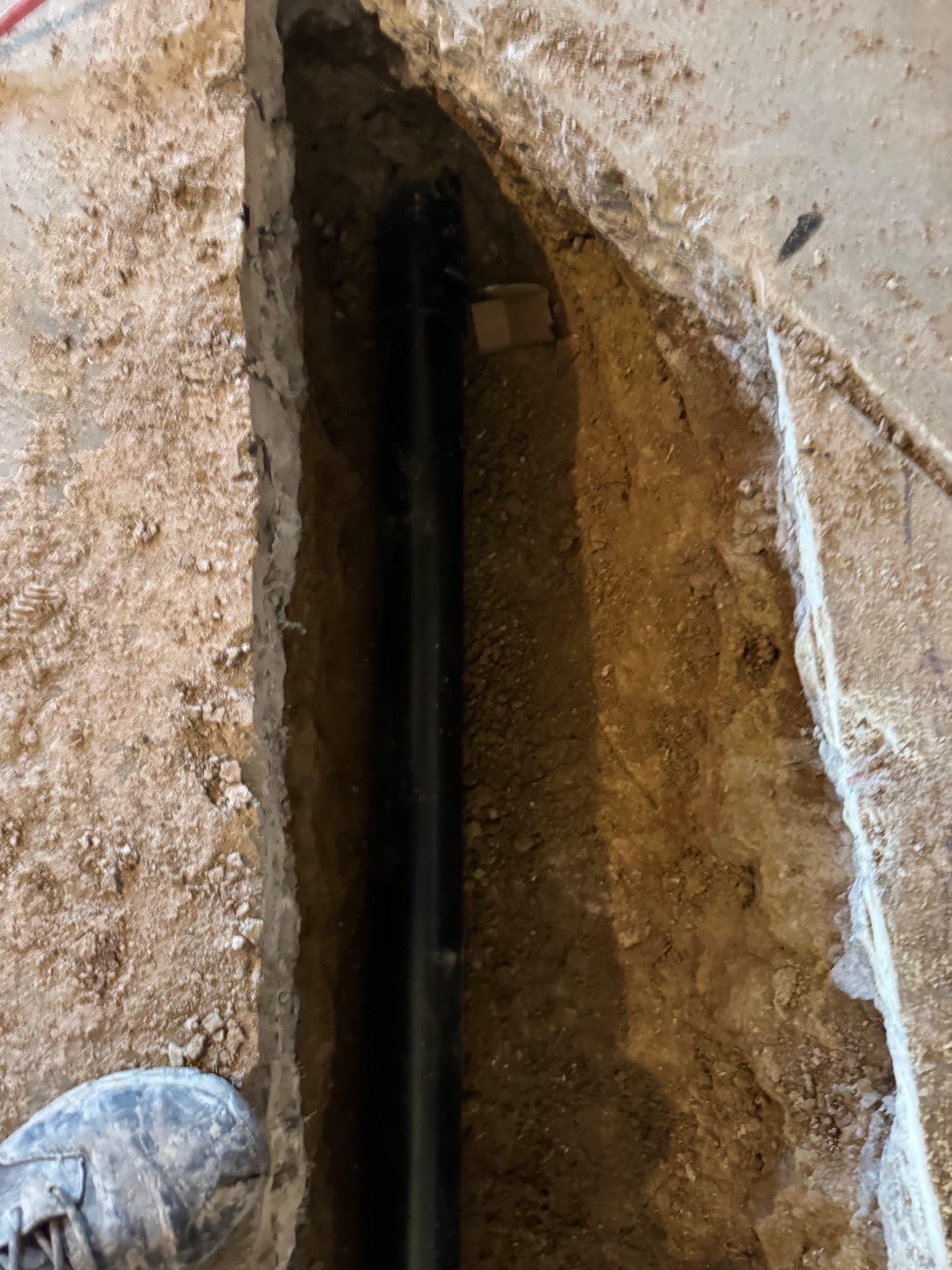 Sewer line repair excavation in Aurora, CO — Zenith Home Services technician exposing a buried sewer pipe in a trench for repair or replacement